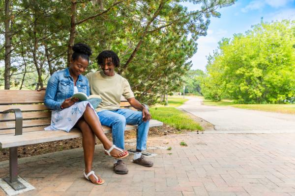 two people reading on park bench