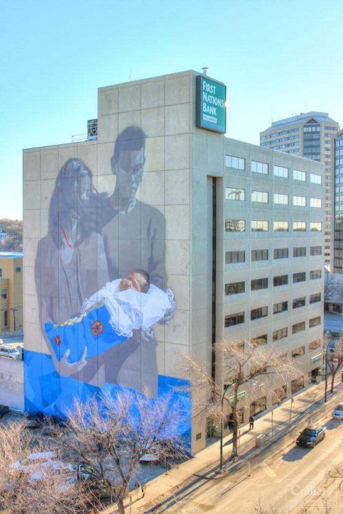 The image shows a large mural painted on the side of First Nations Bank building in downtown Saskatoon.
