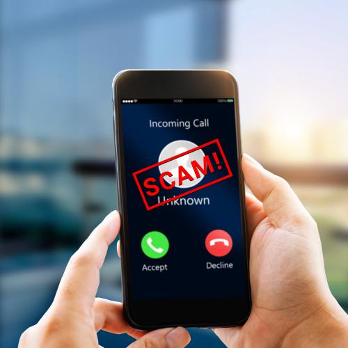 Photo of a smartphone with an incoming call, a red SCAM is superimposed on the front.