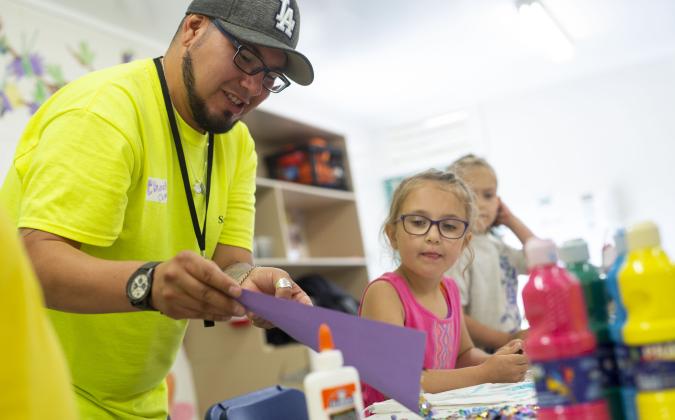worker helping children with crafts